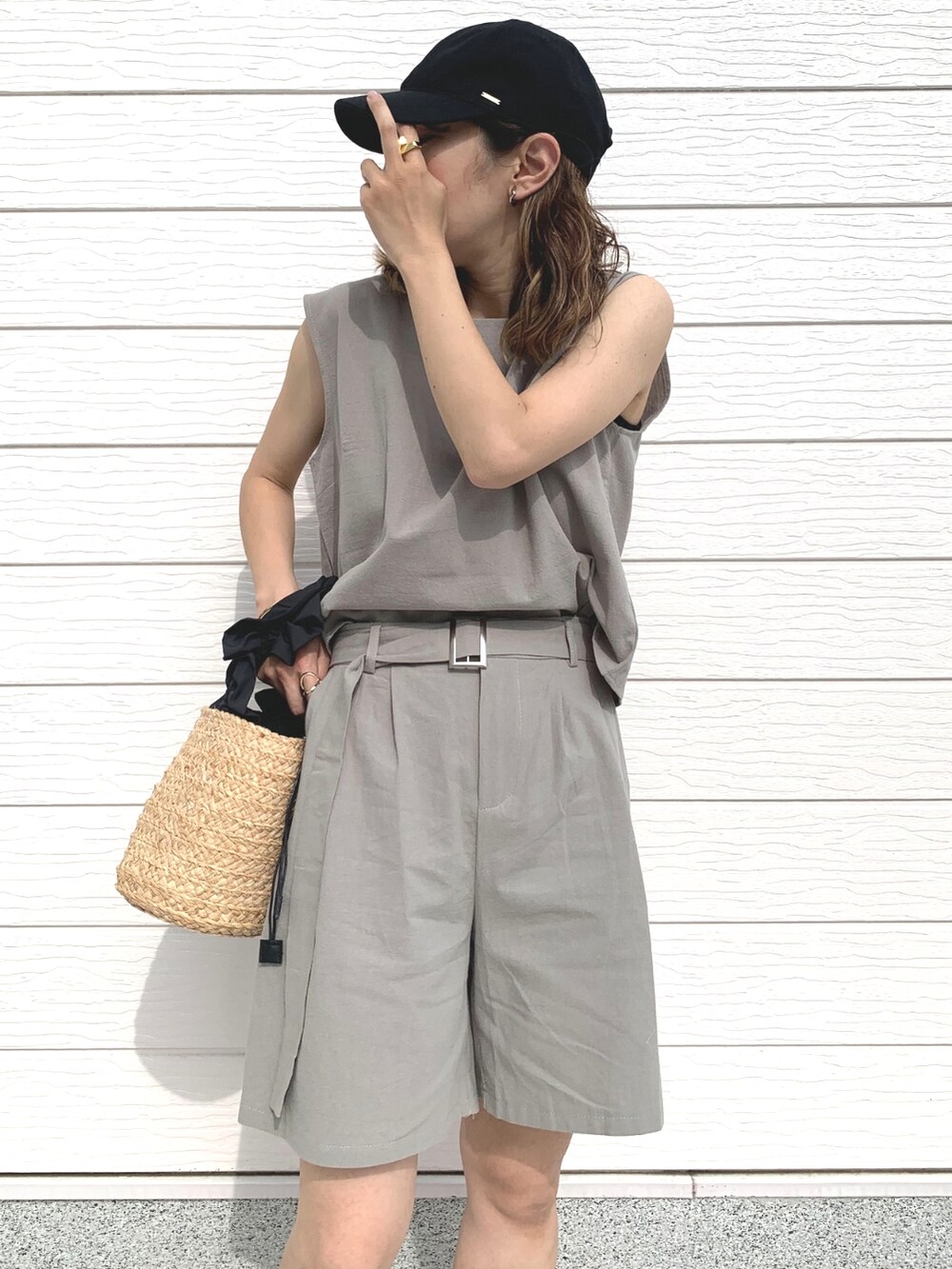 ブラック系のかごバッグ、ブラック系のサンダル、グリーン系のセットアップを着用したレディースの春コーディネートの4枚目の写真