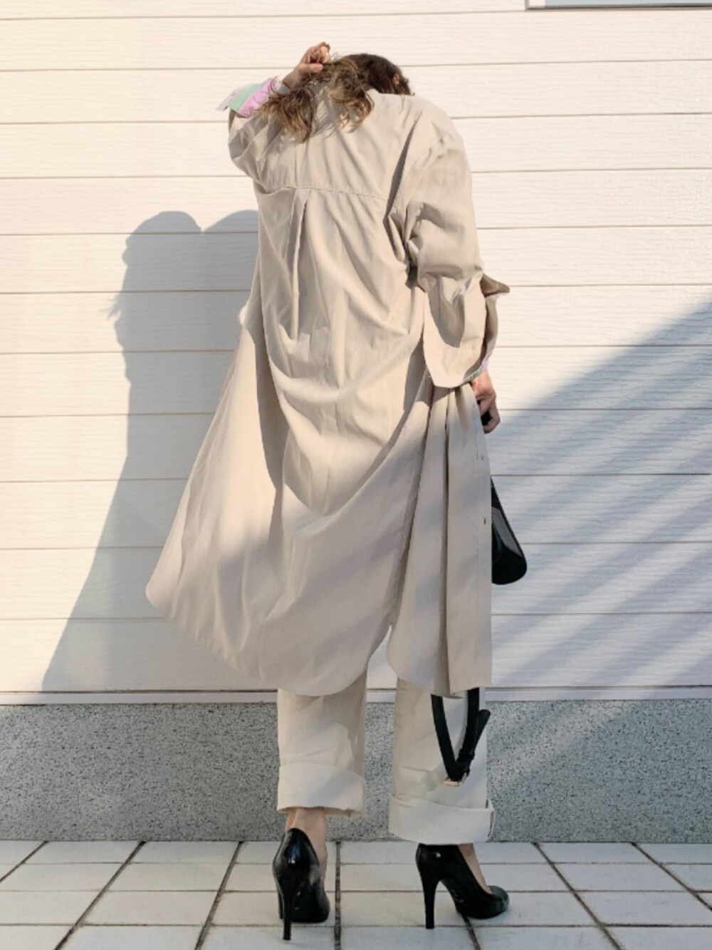 グレー系のTシャツ/カットソー、ブラック系のショルダーバッグ、ホワイト系のデニムパンツを着用したレディースの秋コーディネートの3枚目の写真