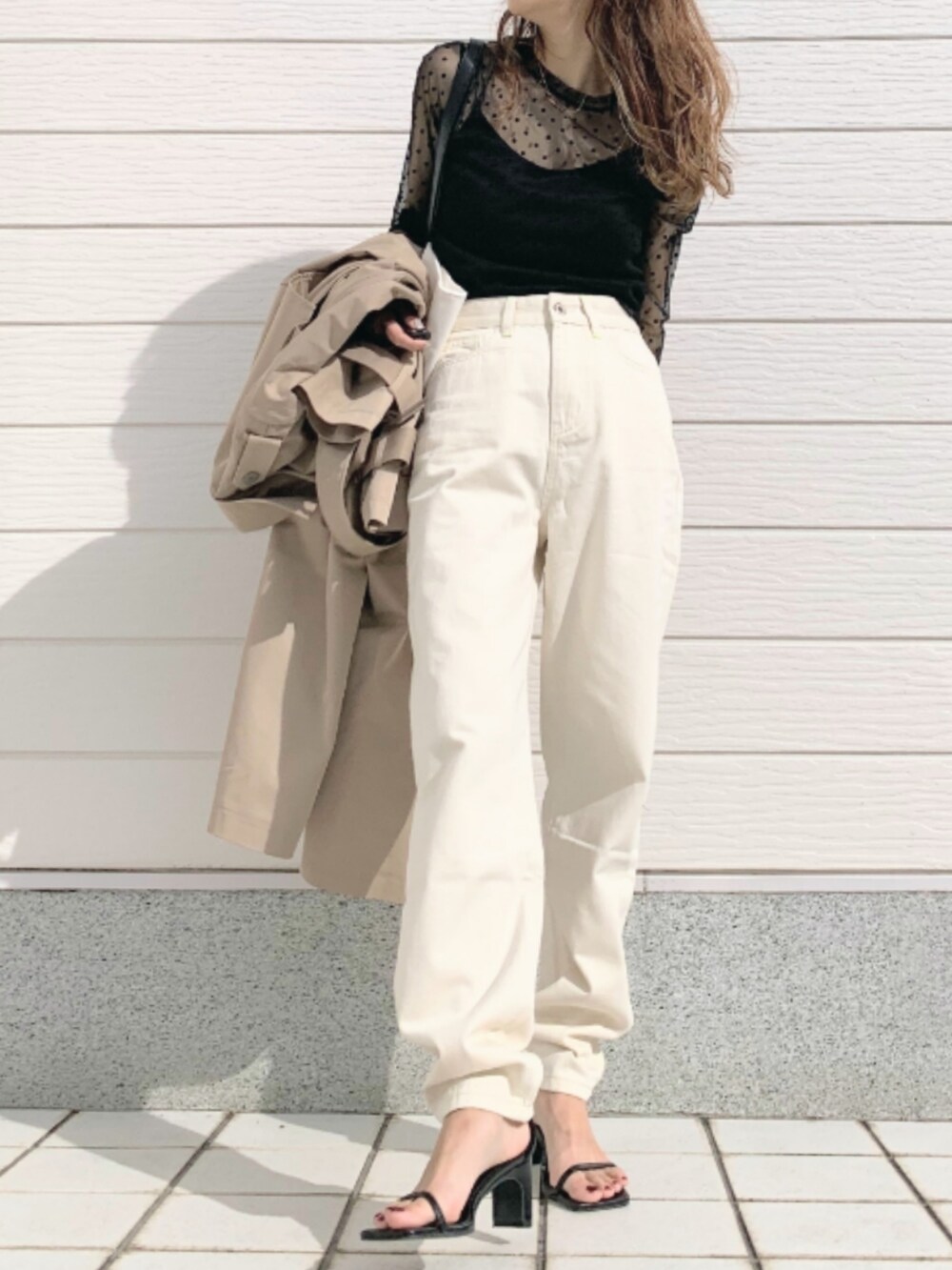 ホワイト系のトートバッグ、ベージュ系のトレンチコート、ブラック系のTシャツ/カットソーを着用したレディースの冬コーディネートの3枚目の写真