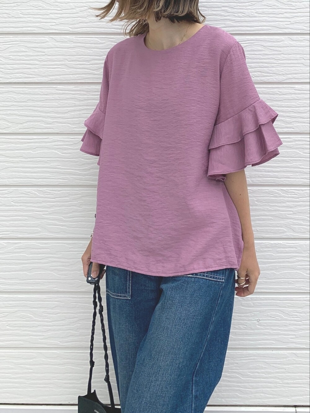 ブルー系のデニムパンツ、ブラック系のサンダル、パープル系のシャツ/ブラウスを着用したレディースの夏コーディネートの2枚目の写真