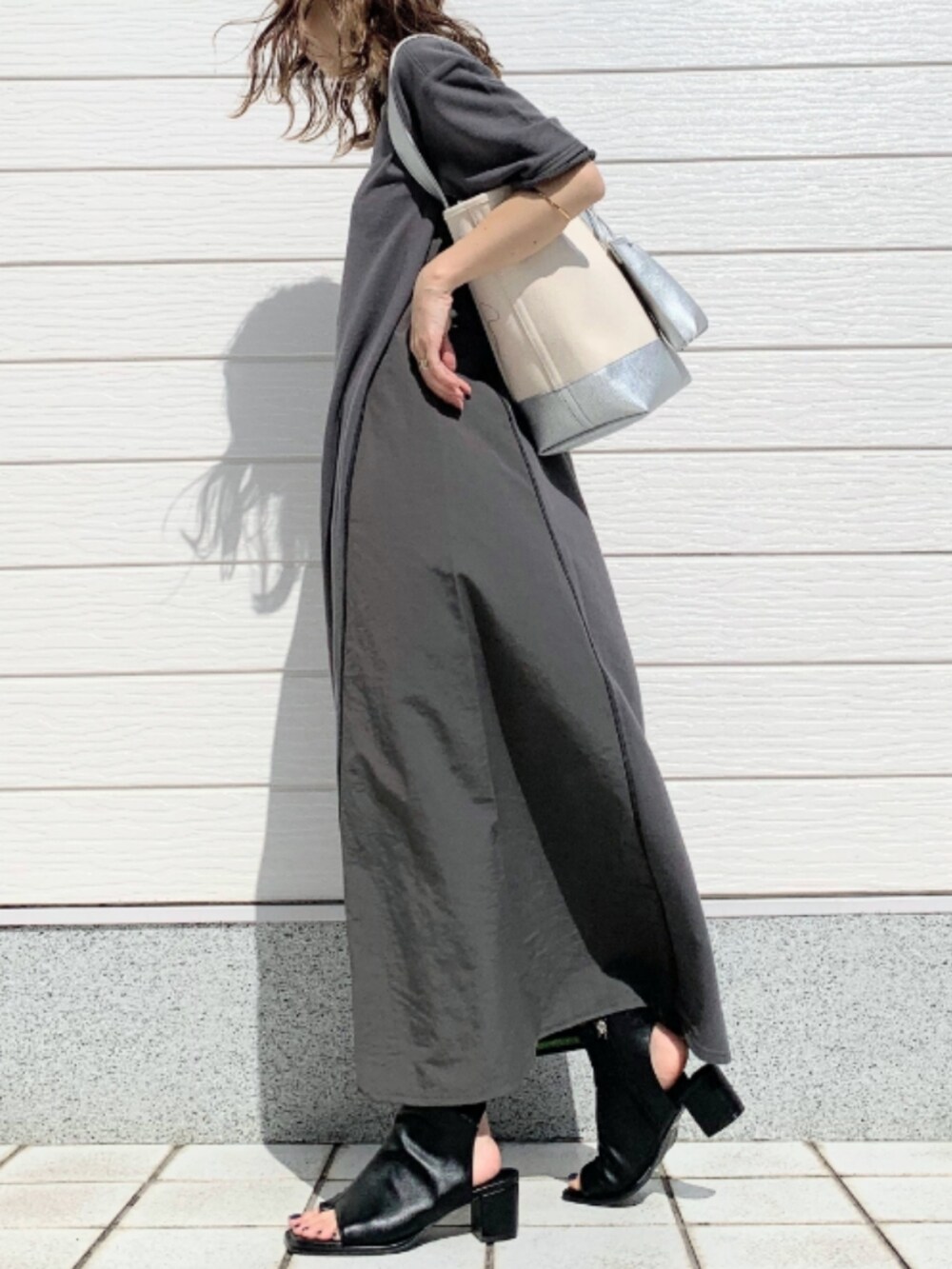 ブラック系のサンダル、グレー系のワンピース、シルバー系のハンドバッグを着用したレディースの春コーディネートの2枚目の写真