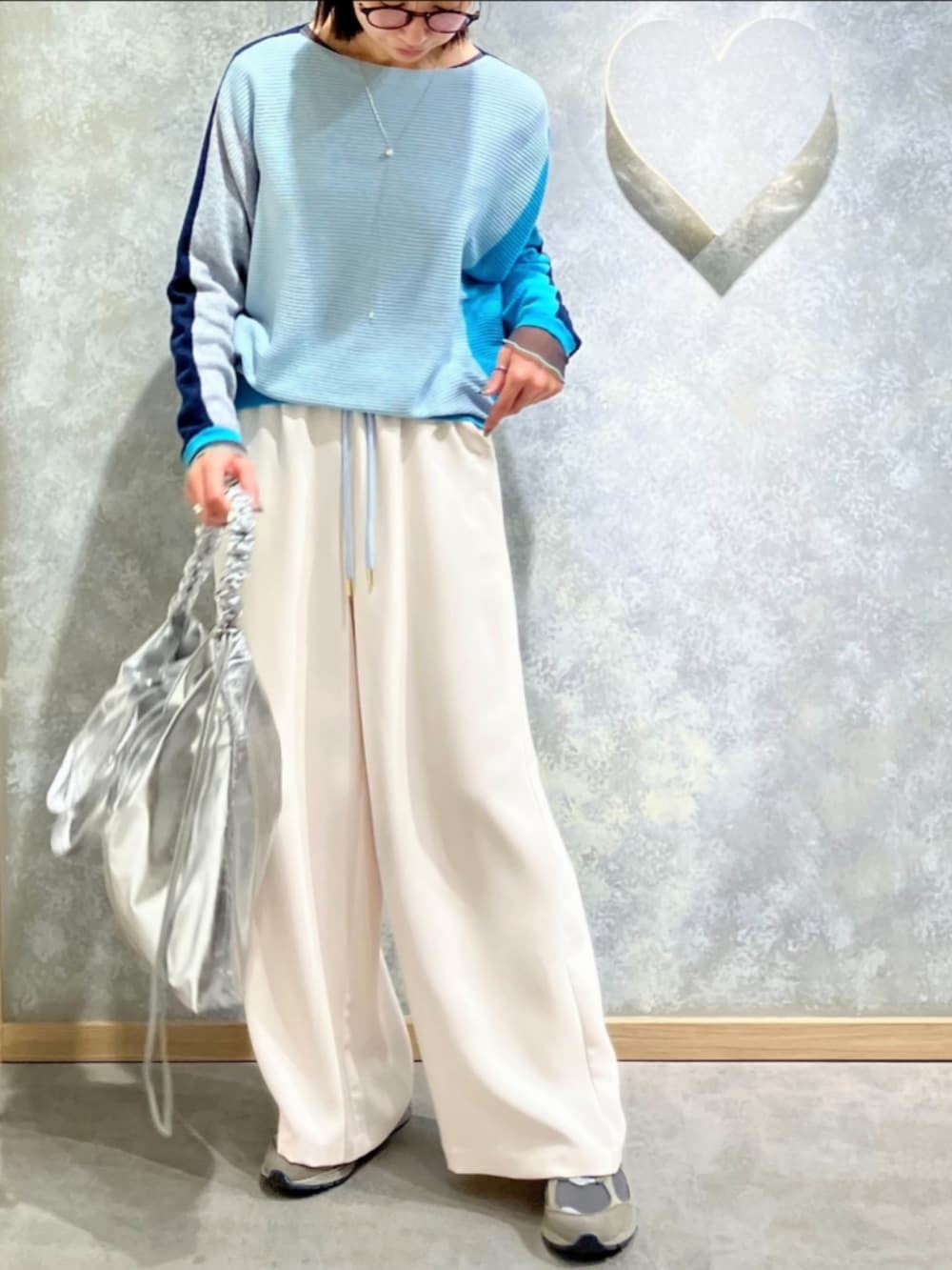 ブルー系のニット/セーター、ホワイト系のその他パンツ、シルバー系のトートバッグを着用したレディースの冬コーディネートの2枚目の写真