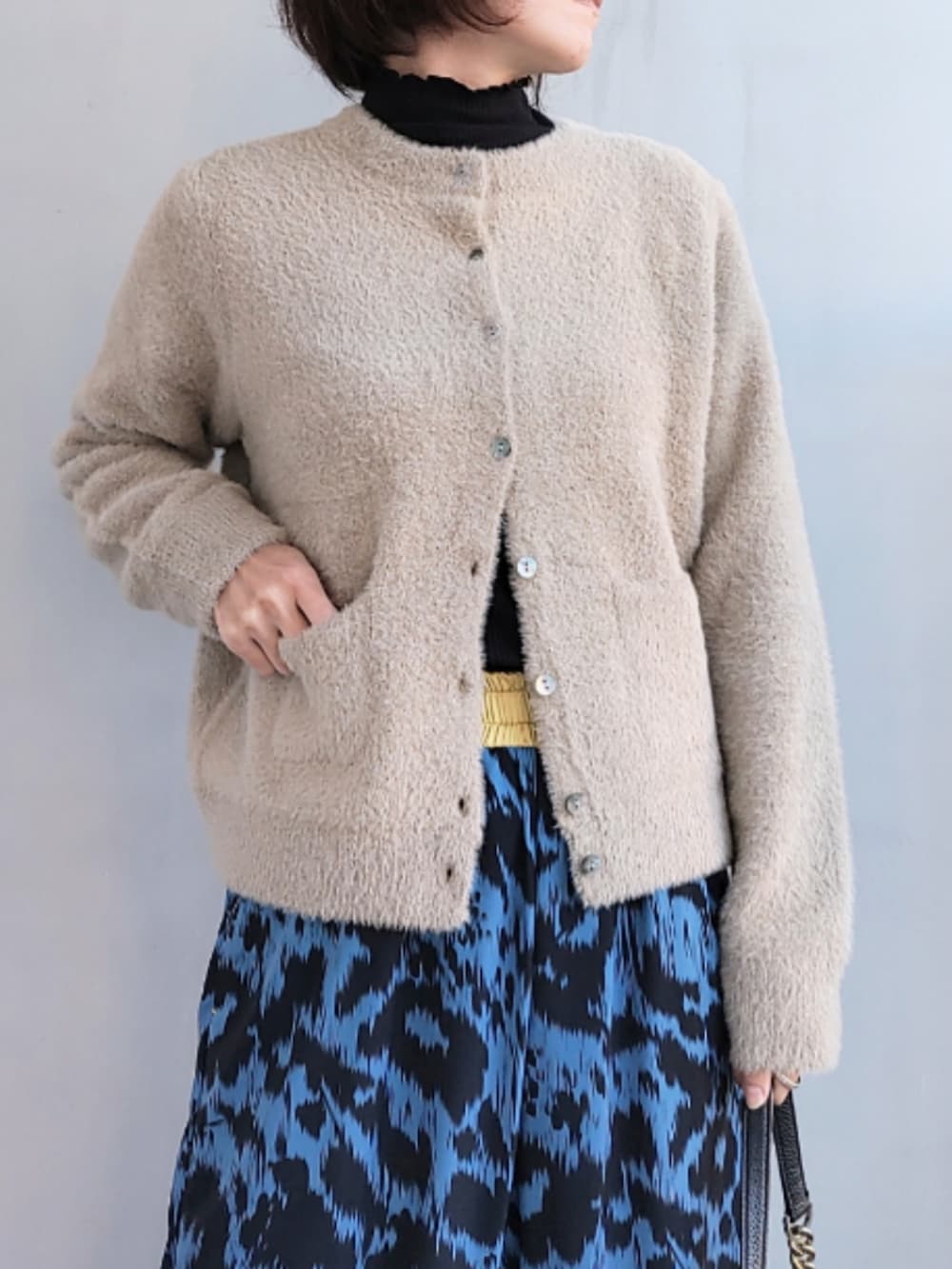 ブルー系のその他パンツ、ブラック系のバッグ、ベージュ系のカーディガン/ボレロを着用したレディースの秋コーディネートの4枚目の写真