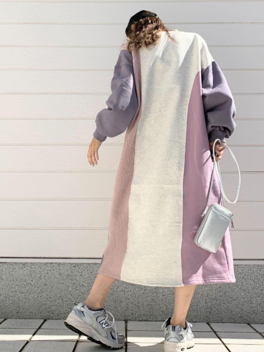 シルバー系のスニーカー、シルバー系のショルダーバッグ、ピンク系のワンピースを着用したレディースの秋コーディネートの3枚目の写真
