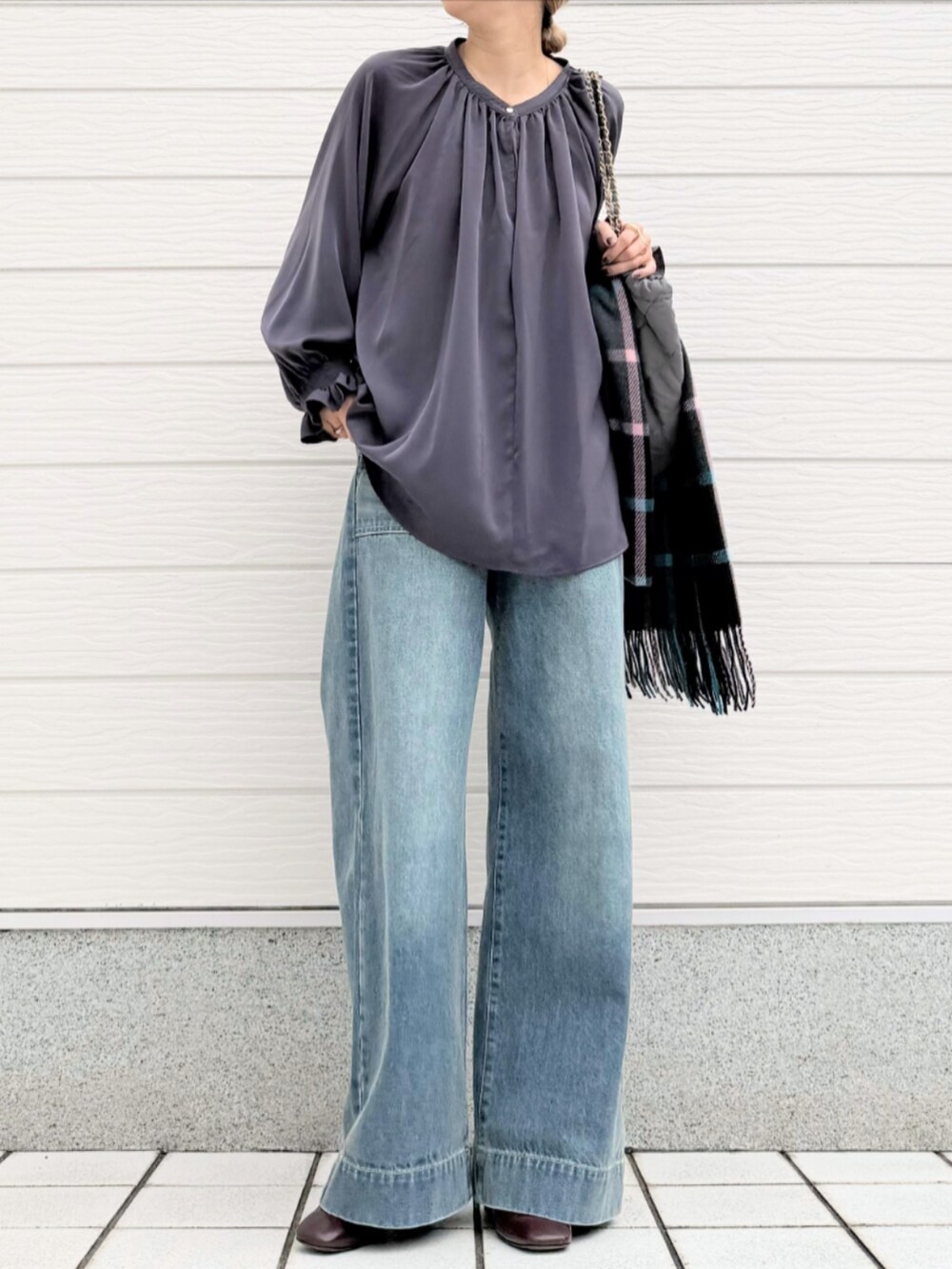 ブルー系のデニムパンツ、グレー系のトートバッグ、グレー系のシャツ/ブラウスを着用したレディースの秋コーディネートの2枚目の写真