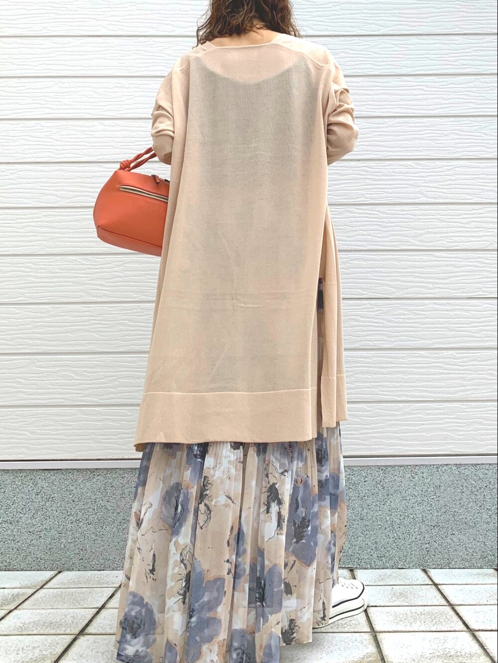 オレンジ系のハンドバッグ、イエロー系のスカート、ホワイト系のスニーカーを着用したレディースの春コーディネートの3枚目の写真