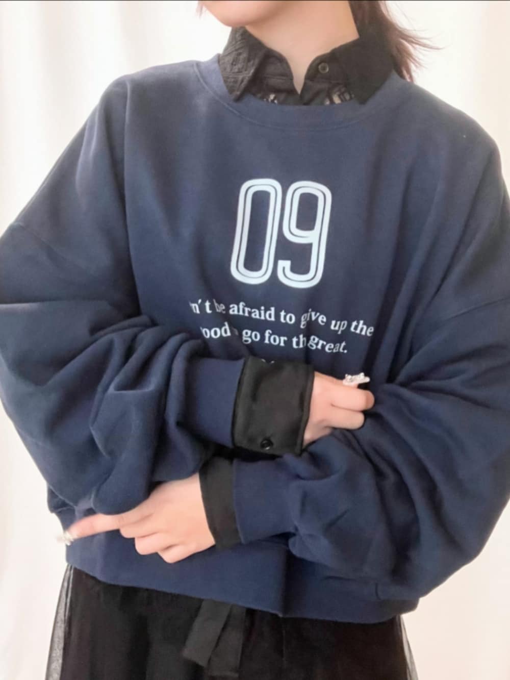 ブラック系のスカート、シルバー系のスニーカー、ブルー系のスウェットを着用したレディースの冬コーディネートの4枚目の写真