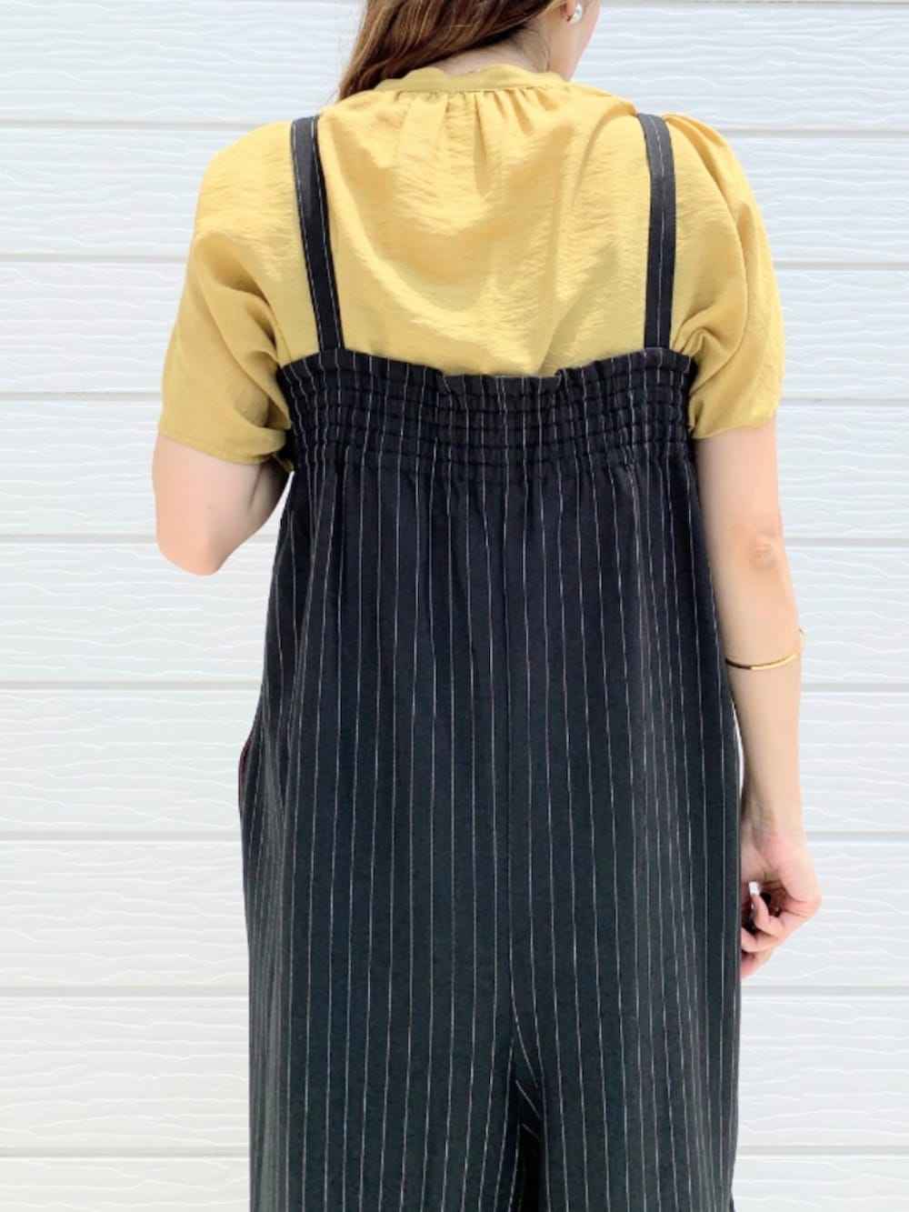 ブラウン系のサンダル、イエロー系のシャツ/ブラウス、ブラック系のサロペット/オーバーオールを着用したレディースの夏コーディネートの4枚目の写真