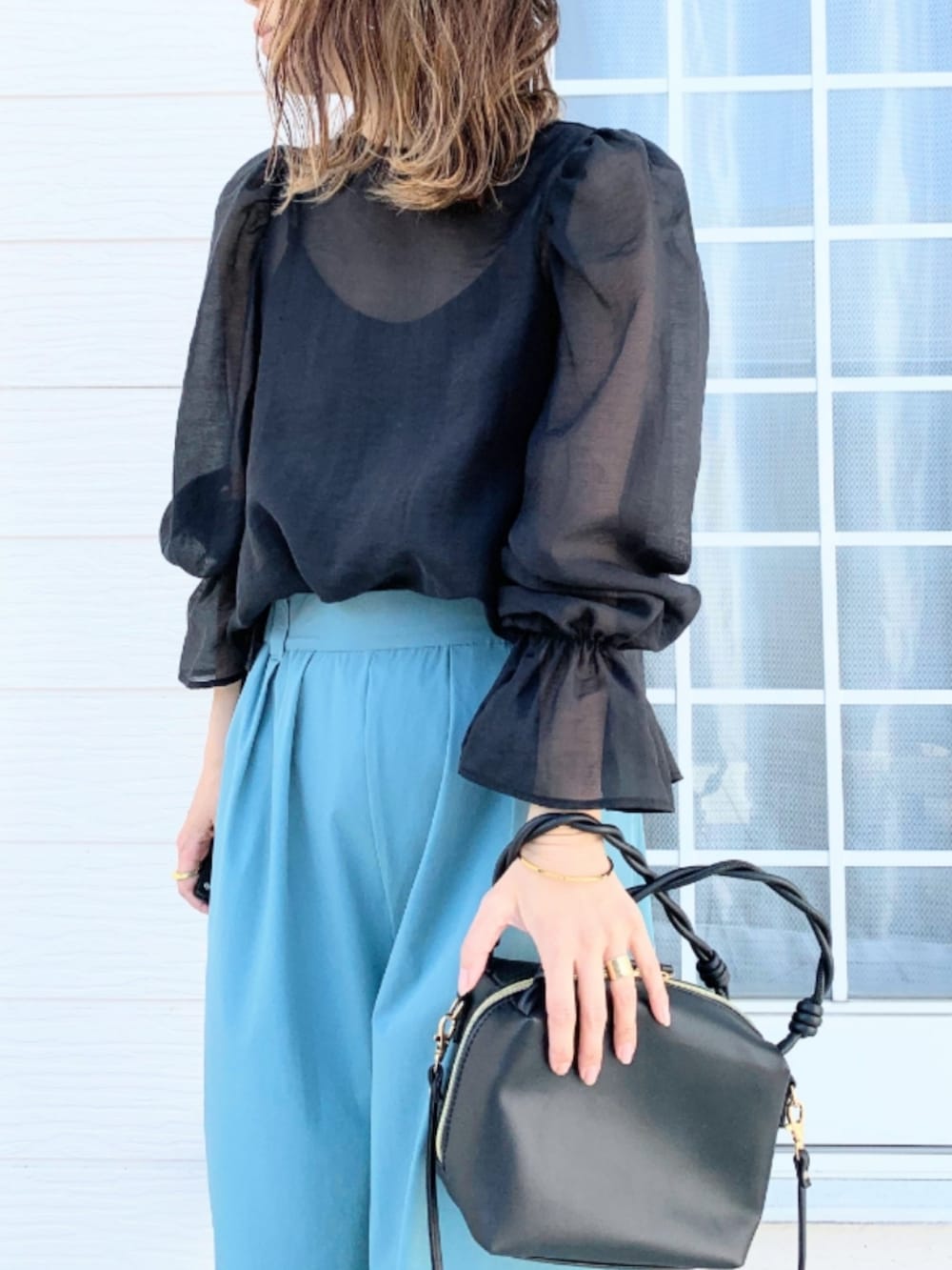 ブラック系のハンドバッグ、ブルー系のその他パンツ、ブラック系のシャツ/ブラウスを着用したレディースの春コーディネートの4枚目の写真