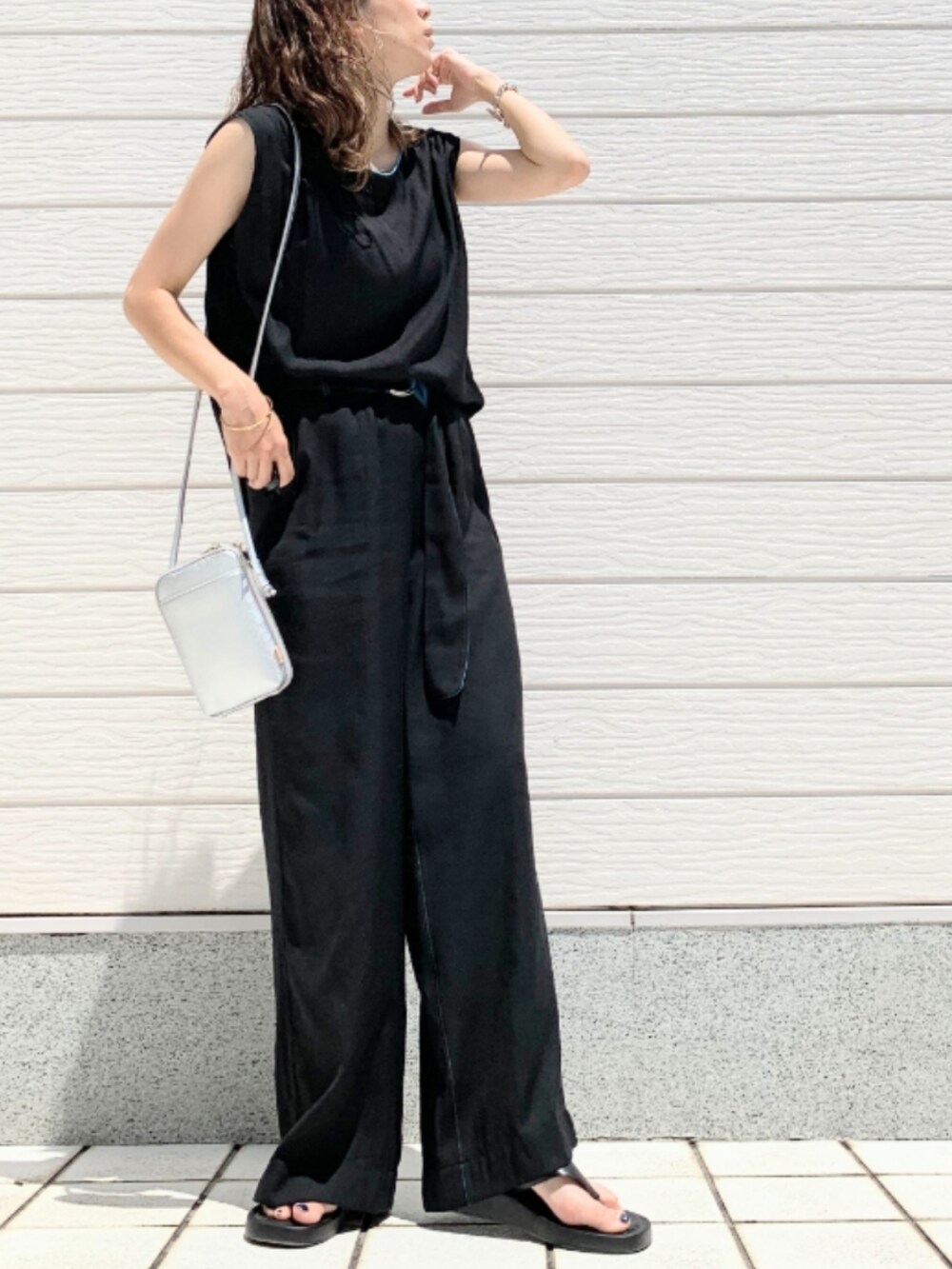 ブラック系のその他パンツ、ブラック系のシャツ/ブラウス、シルバー系のショルダーバッグを着用したレディースの夏コーディネートの2枚目の写真