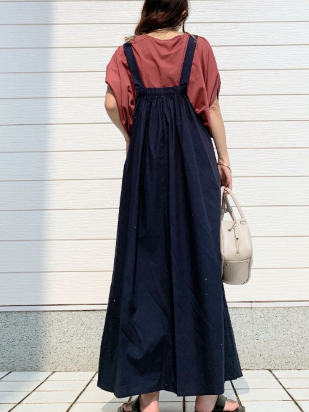 レッド系のTシャツ/カットソー、ブルー系のジャンパースカート、ホワイト系のボストンバッグを着用したレディースの夏コーディネートの3枚目の写真