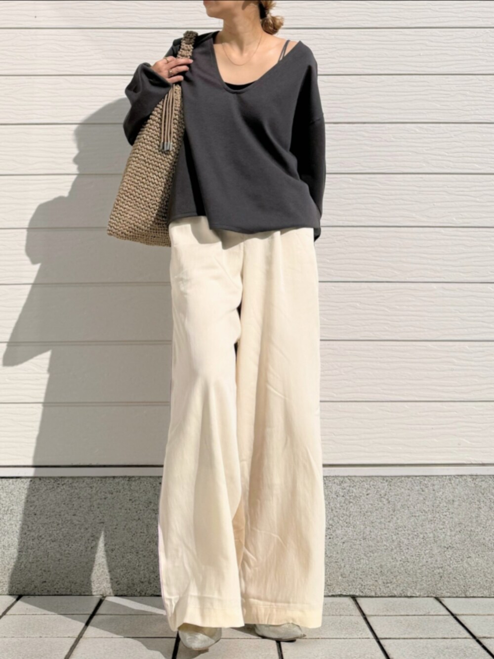 グレー系のTシャツ/カットソー、ベージュ系のトートバッグ、ホワイト系のその他パンツを着用したレディースの冬コーディネートの2枚目の写真