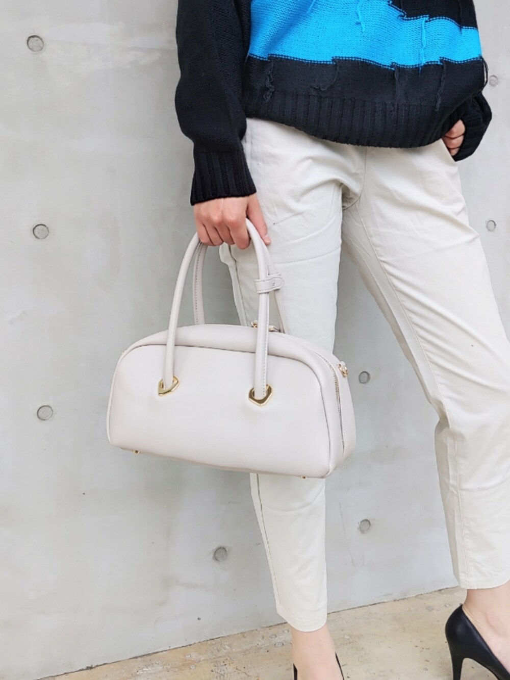 ホワイト系のその他パンツ、ホワイト系のボストンバッグ、ブラック系のニット/セーターを着用したレディースの秋コーディネートの4枚目の写真