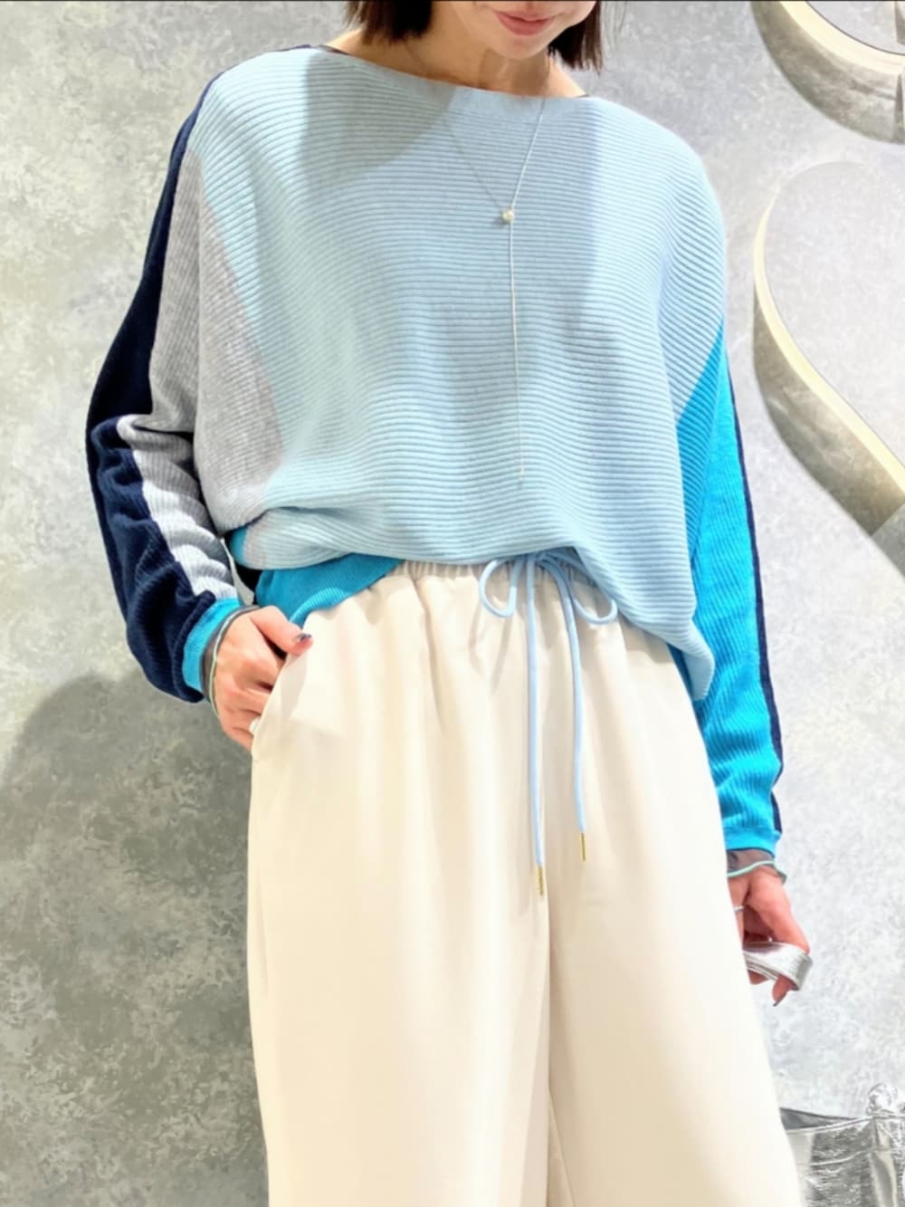 ブルー系のニット/セーター、ホワイト系のその他パンツ、シルバー系のトートバッグを着用したレディースの冬コーディネートの4枚目の写真