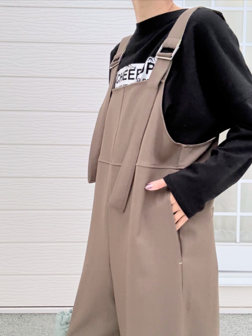 グリーン系のトートバッグ、ブラック系のTシャツ/カットソー、ブラウン系のブーツを着用したレディースの秋コーディネートの5枚目の写真