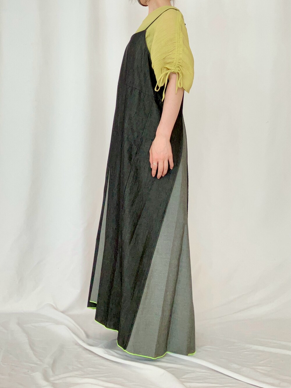 イエロー系のシャツ/ブラウス、ブラック系のワンピース、グレー系のサンダルを着用したレディースの夏コーディネートの2枚目の写真