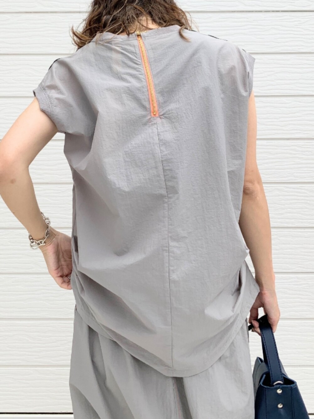 ブルー系のハンドバッグ、グレー系のTシャツ/カットソー、グレー系のスカートを着用したレディースの夏コーディネートの5枚目の写真