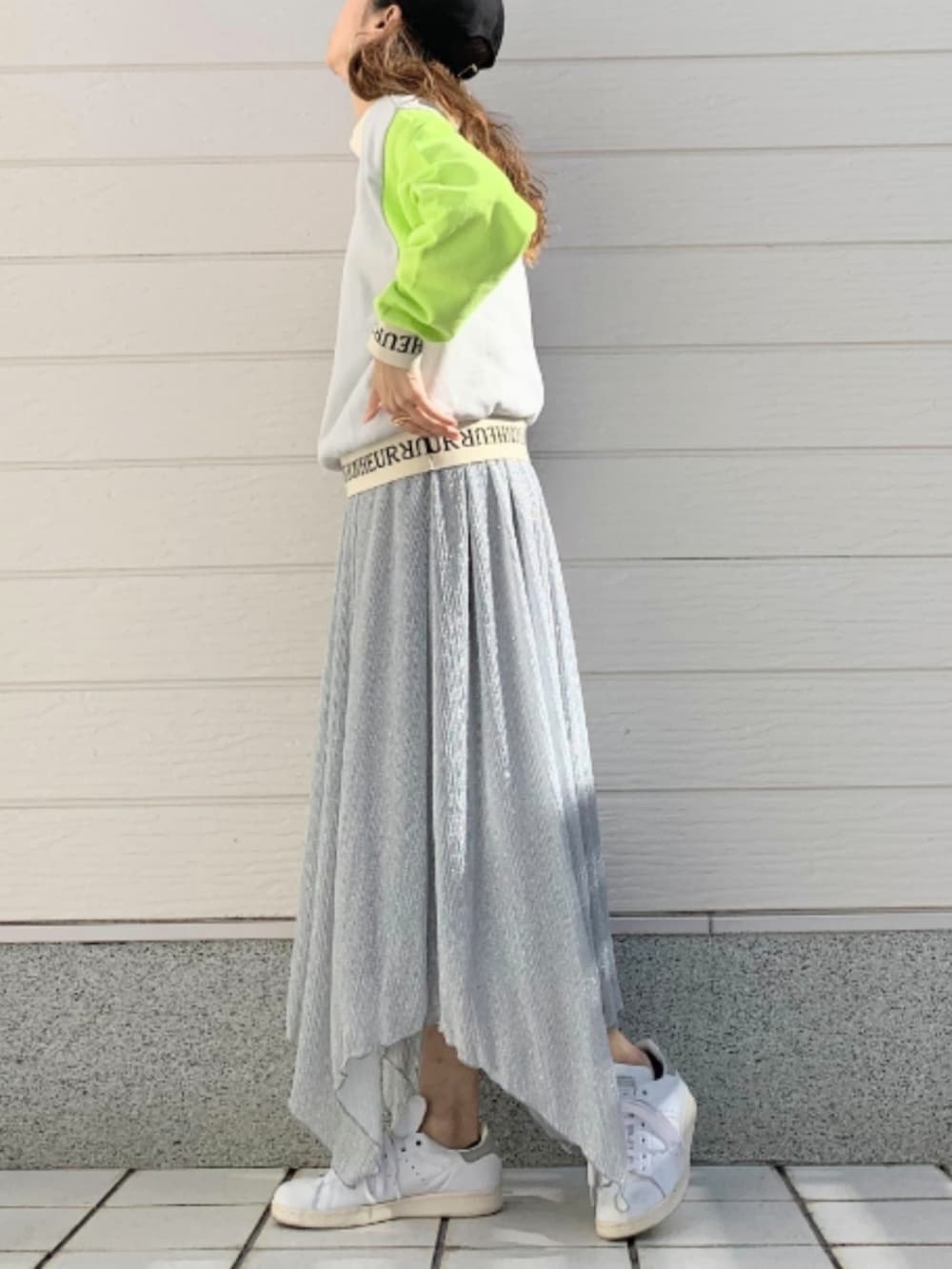 シルバー系のスカート、ホワイト系のスニーカー、グレー系のスウェットを着用したレディースの冬コーディネートの2枚目の写真