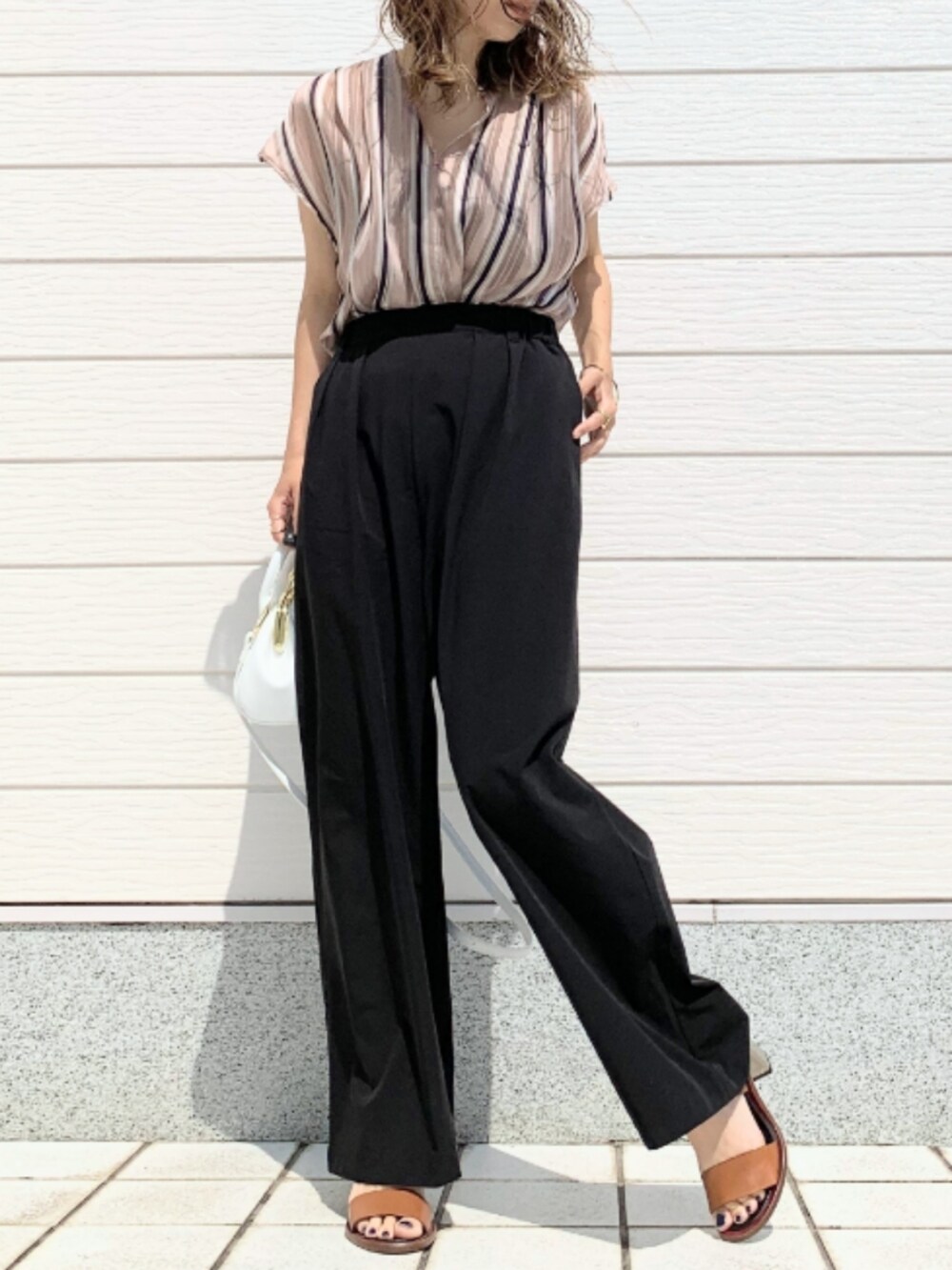 ホワイト系のショルダーバッグ、ブラック系のその他パンツ、ブラウン系のサンダルを着用したレディースの春コーディネートの2枚目の写真