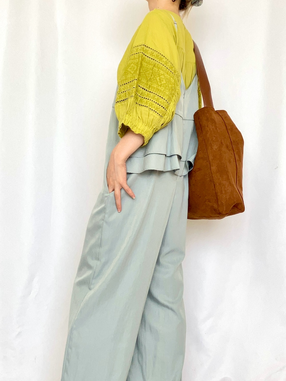 イエロー系のトートバッグ、ブルー系のサロペット/オーバーオール、グレー系のサンダルを着用したレディースの夏コーディネートの4枚目の写真