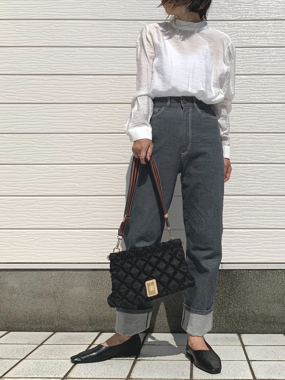 グレー系のデニムパンツ、ブラック系のショルダーバッグ、ホワイト系のシャツ/ブラウスを着用したレディースの夏コーディネートの2枚目の写真
