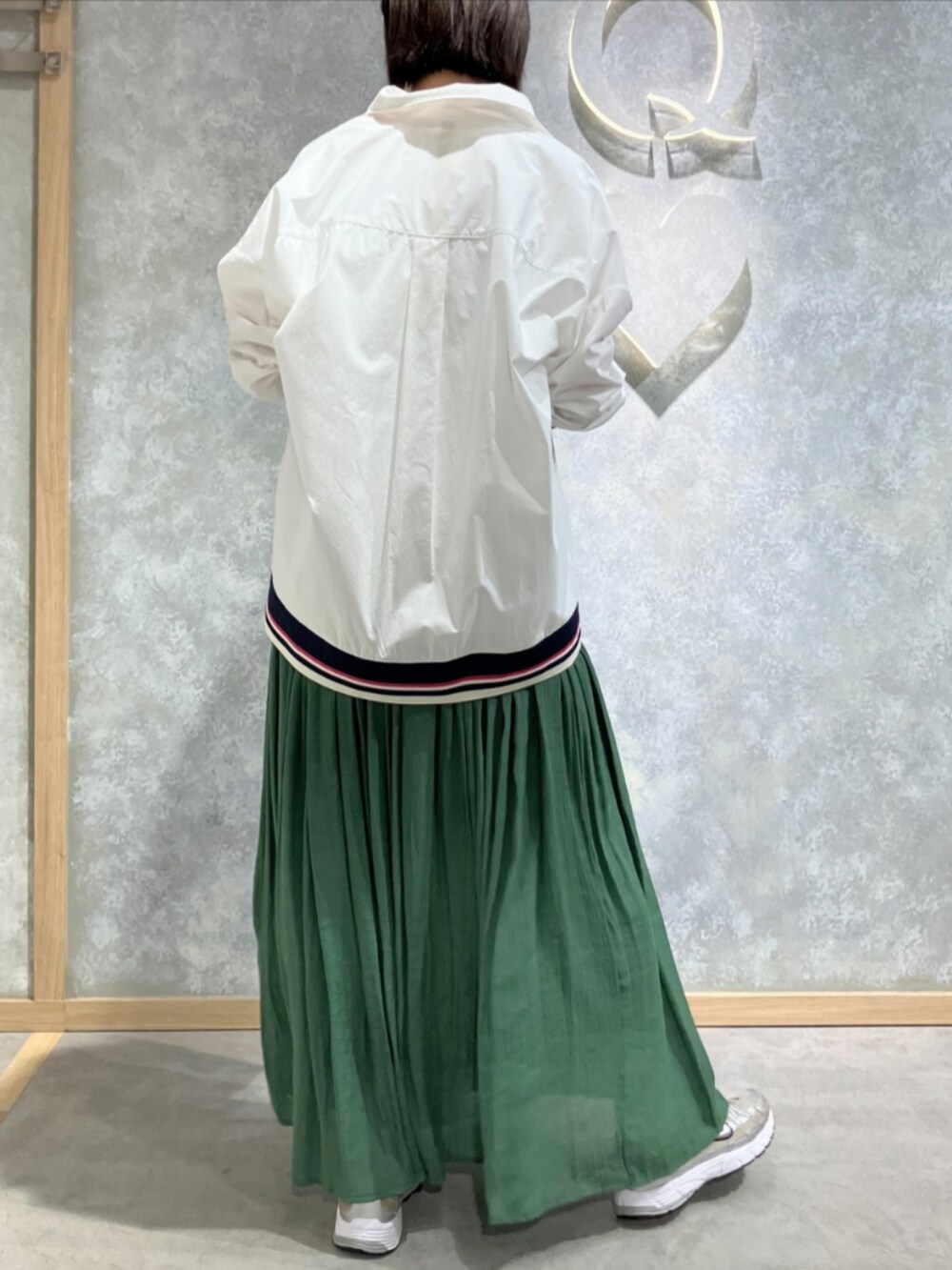 シルバー系のトートバッグ、グリーン系のスカート、ホワイト系のTシャツ/カットソーを着用したレディースの秋コーディネートの4枚目の写真