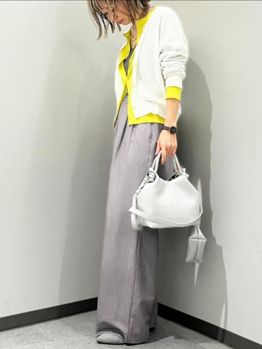 グレー系のスラックス、ホワイト系のTシャツ/カットソー、ホワイト系のカーディガン/ボレロを着用したレディースの春コーディネートの3枚目の写真