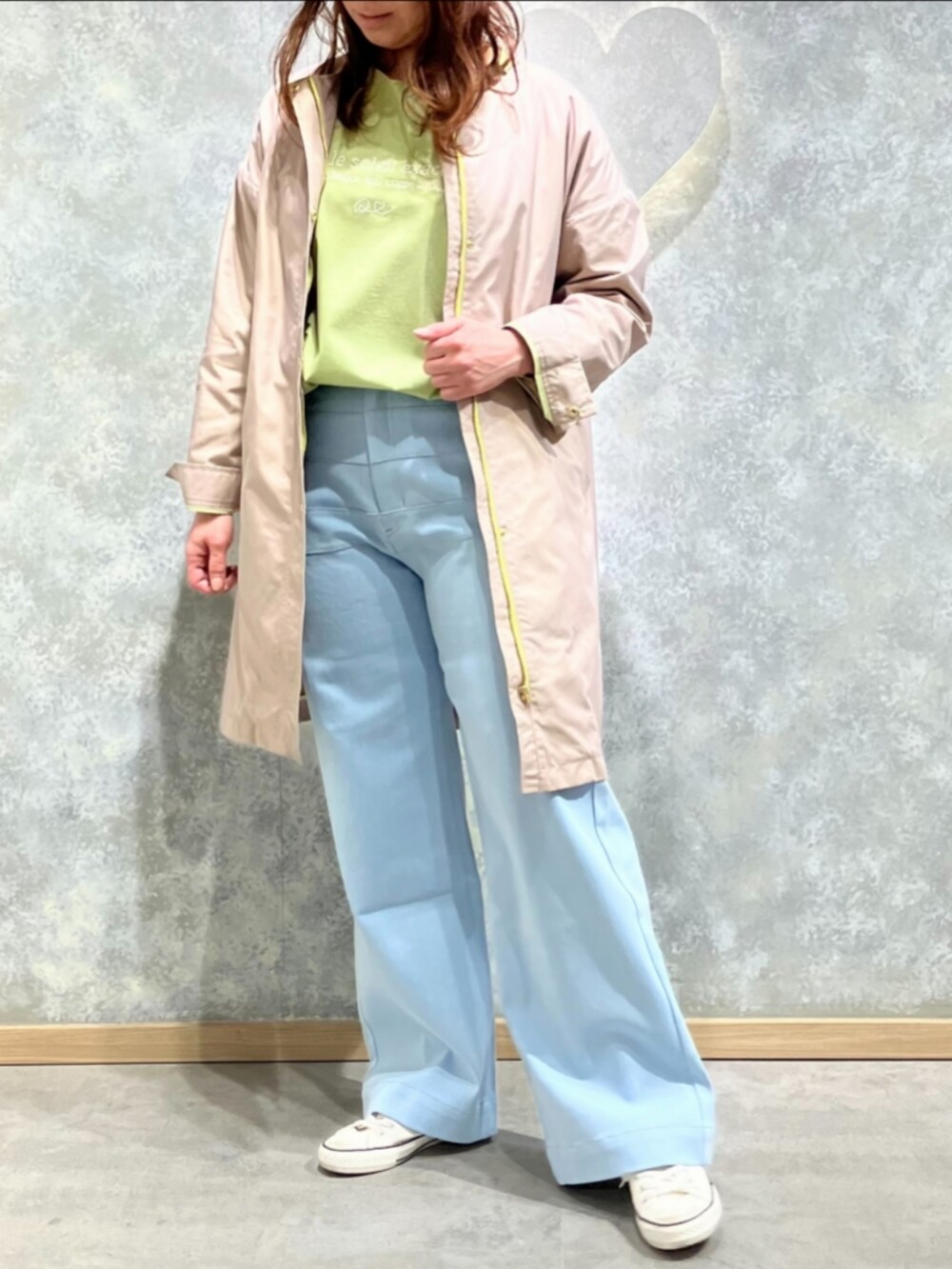 ブルー系のデニムパンツ、グリーン系のTシャツ/カットソー、ベージュ系のノーカラーコートを着用したレディースの冬コーディネートの2枚目の写真