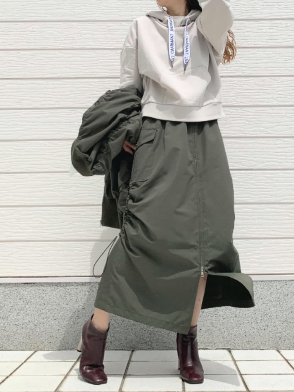 ブラウン系のブーツ、グリーン系のMA-1、グリーン系のスカートを着用したレディースの夏コーディネートの2枚目の写真