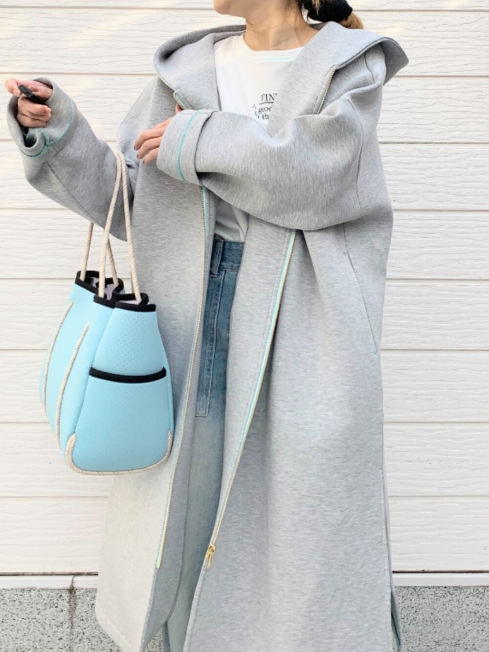 ブルー系のトートバッグ、ホワイト系のTシャツ/カットソー、グレー系のその他アウターを着用したレディースの冬コーディネートの4枚目の写真