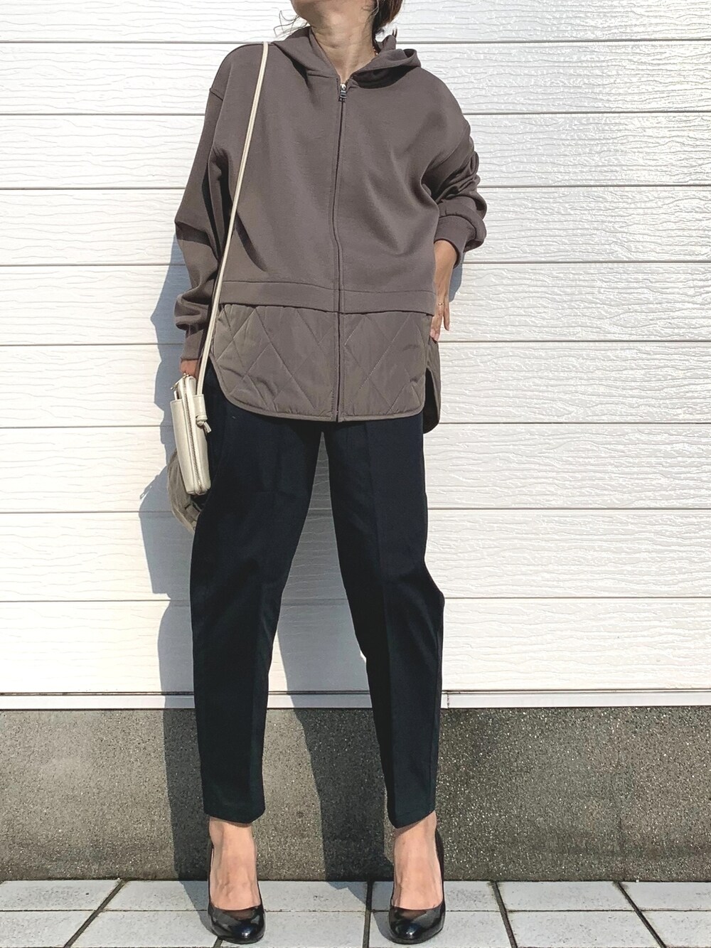 ブラック系のその他パンツ、ホワイト系のショルダーバッグ、ベージュ系のブルゾンを着用したレディースの秋コーディネートの3枚目の写真