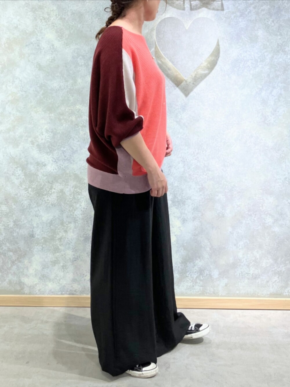 ブラック系のスニーカー、ブラック系のその他パンツ、レッド系のニット/セーターを着用したレディースの秋コーディネートの2枚目の写真