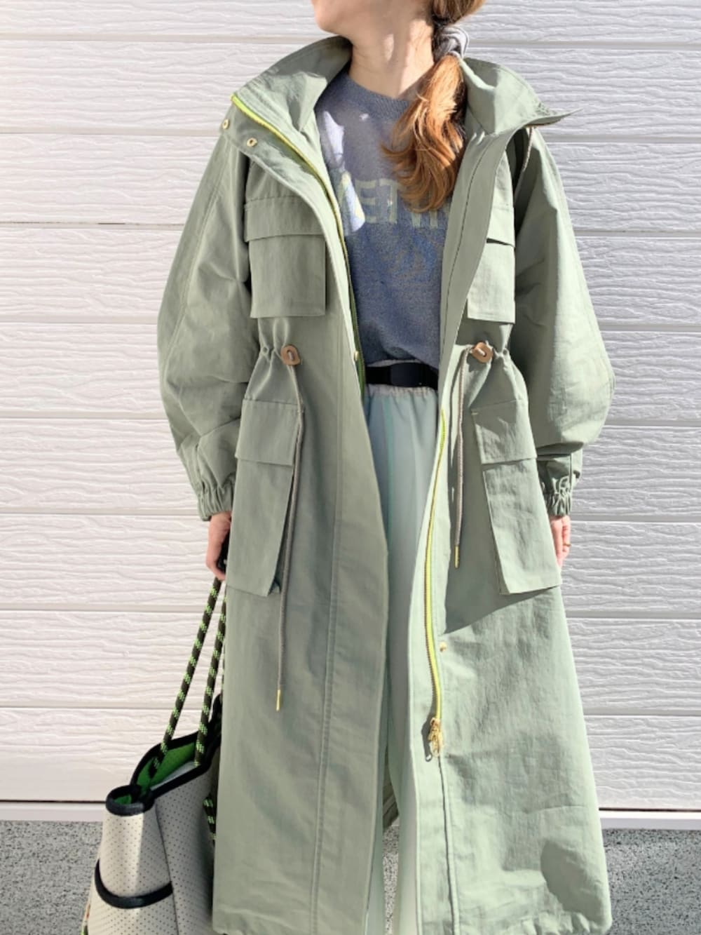 ベージュ系のその他パンツ、グレー系のトートバッグ、グリーン系のモッズコートを着用したレディースの冬コーディネートの3枚目の写真