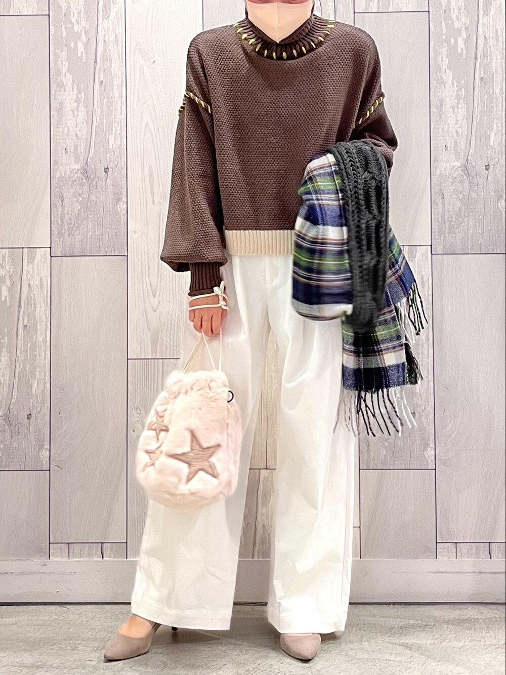 ベージュ系のショルダーバッグ、ホワイト系のデニムパンツ、ブラウン系のニット/セーターを着用したレディースの秋コーディネートの2枚目の写真