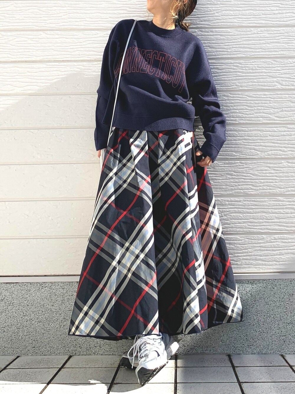 ブルー系のニット/セーター、シルバー系のスニーカー、ブルー系のスカートを着用したレディースの秋コーディネートの2枚目の写真