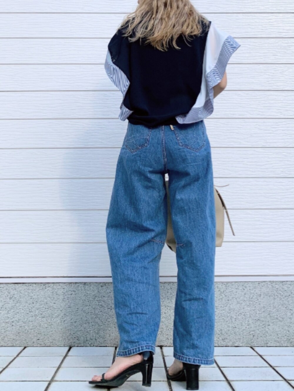 ブルー系のデニムパンツ、ベージュ系のボディバッグ/ウエストポーチ、ブルー系のシャツ/ブラウスを着用したレディースの春コーディネートの3枚目の写真