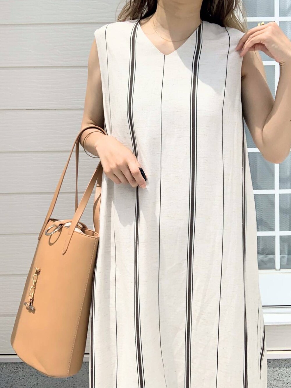 ベージュ系のトートバッグ、グリーン系のワンピースを着用したレディースの春コーディネートの4枚目の写真