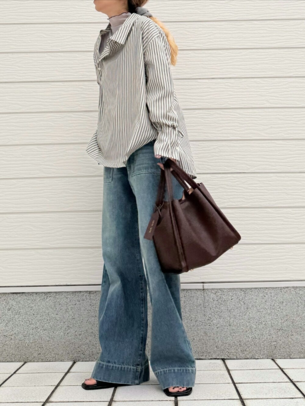 ブラウン系のハンドバッグ、ブラック系のシャツ/ブラウス、グレー系のTシャツ/カットソーを着用したレディースの秋コーディネートの2枚目の写真