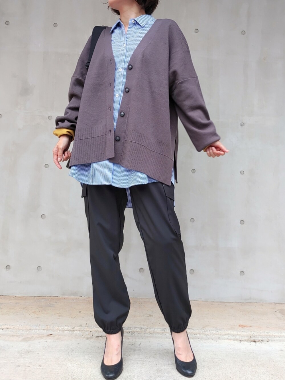 ブラック系のカーゴパンツ、グレー系のカーディガン/ボレロ、ブラック系のクラッチバッグを着用したレディースの秋コーディネートの2枚目の写真
