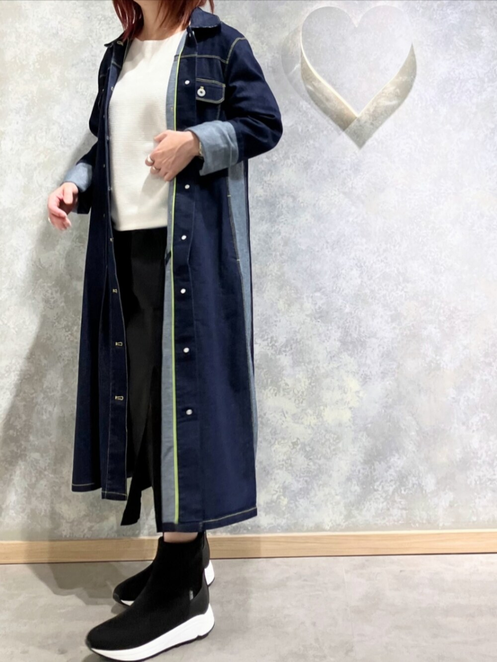 グレー系のブーツ、ブルー系のデニムジャケット、ブラック系のスカートを着用したレディースの秋コーディネートの2枚目の写真