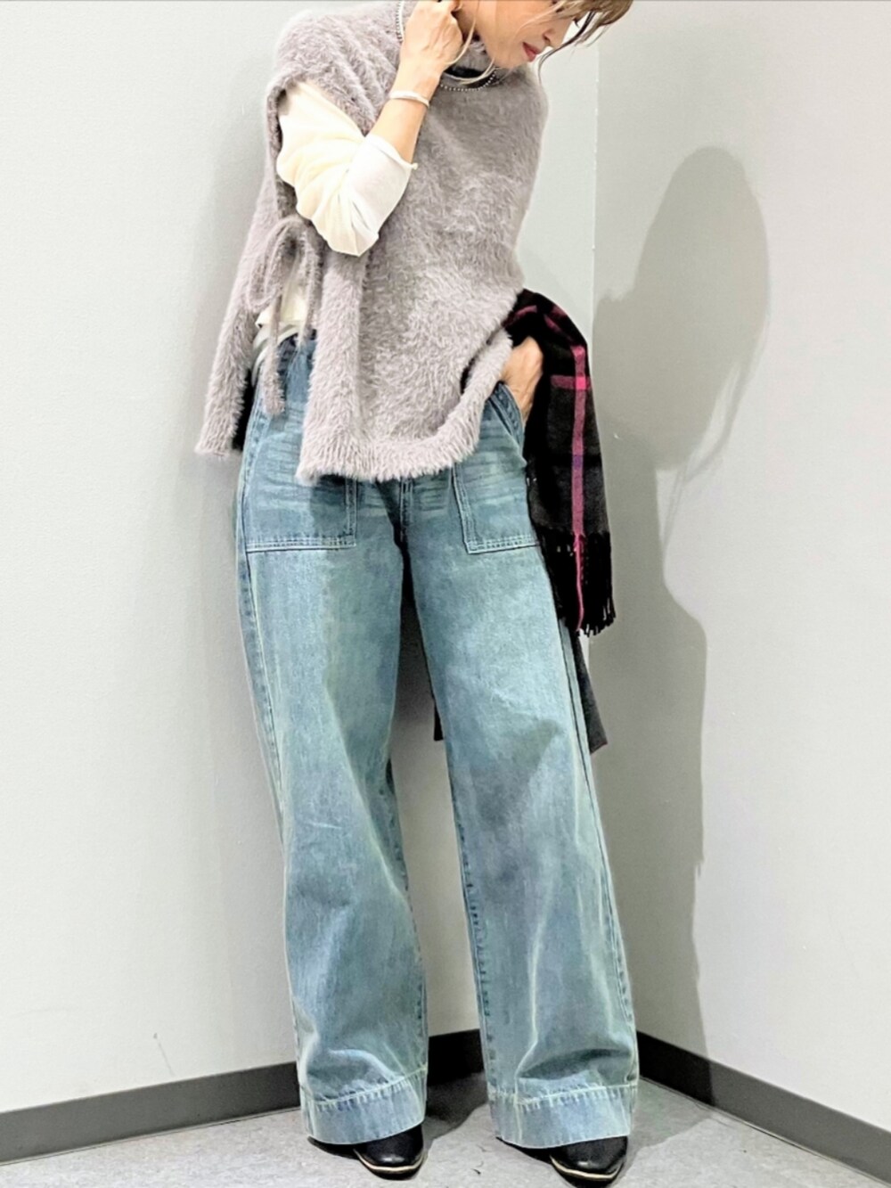 ブルー系のデニムパンツ、グレー系のベスト、ベージュ系のTシャツ/カットソーを着用したレディースの秋コーディネートの2枚目の写真
