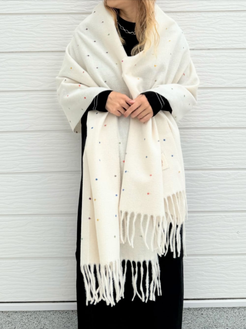 ブラック系のスニーカー、ブラック系のワンピース、ホワイト系のストール/ショールを着用したレディースの秋コーディネートの5枚目の写真