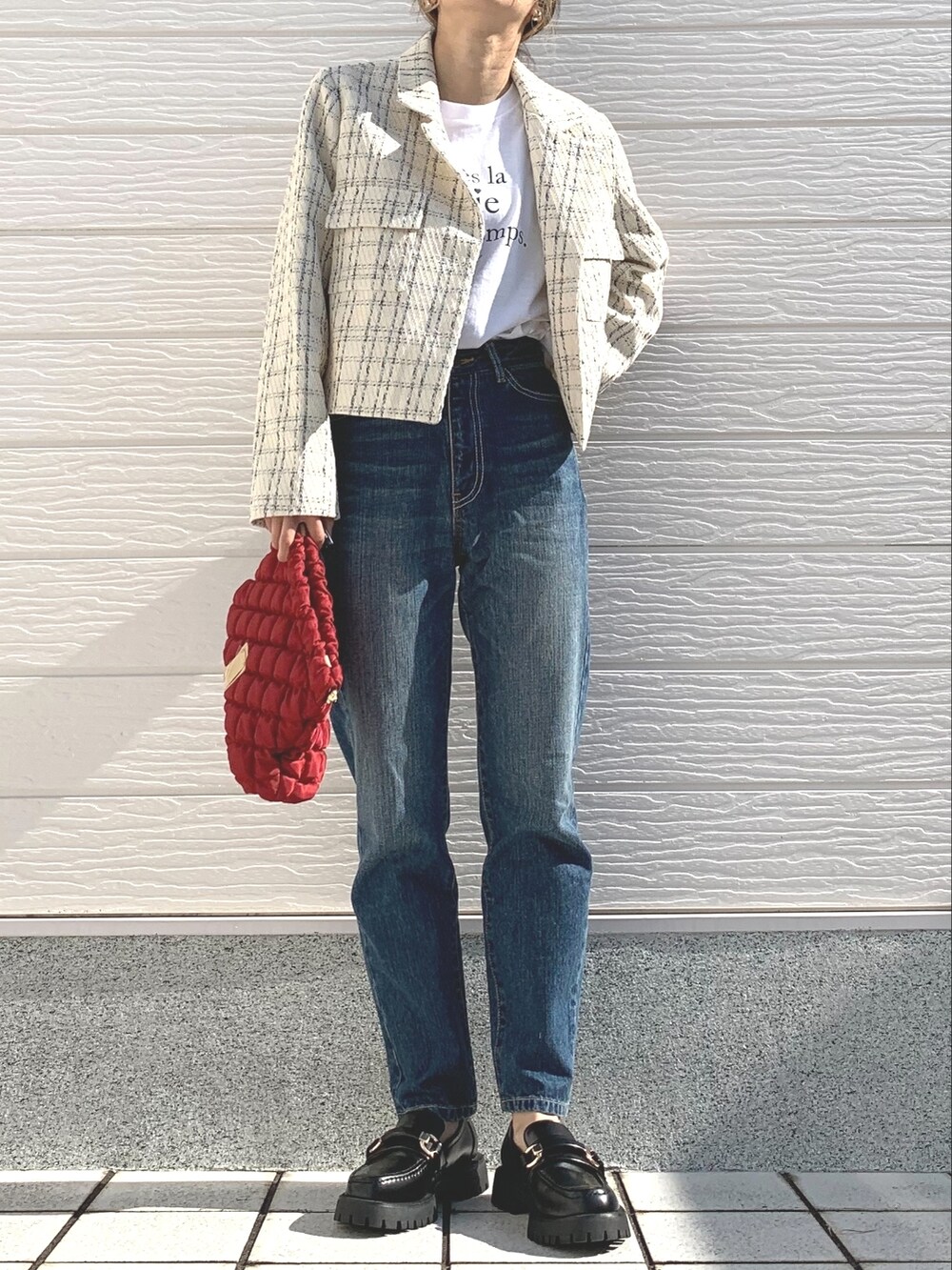 ブルー系のデニムパンツ、ブラック系のローファー、ホワイト系のTシャツ/カットソーを着用したレディースの秋コーディネートの2枚目の写真