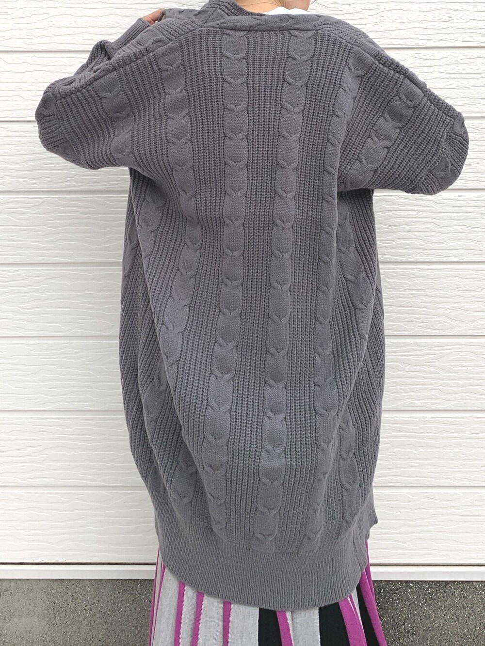 ブラック系のスカート、シルバー系のスニーカー、ホワイト系のTシャツ/カットソーを着用したレディースの秋コーディネートの2枚目の写真