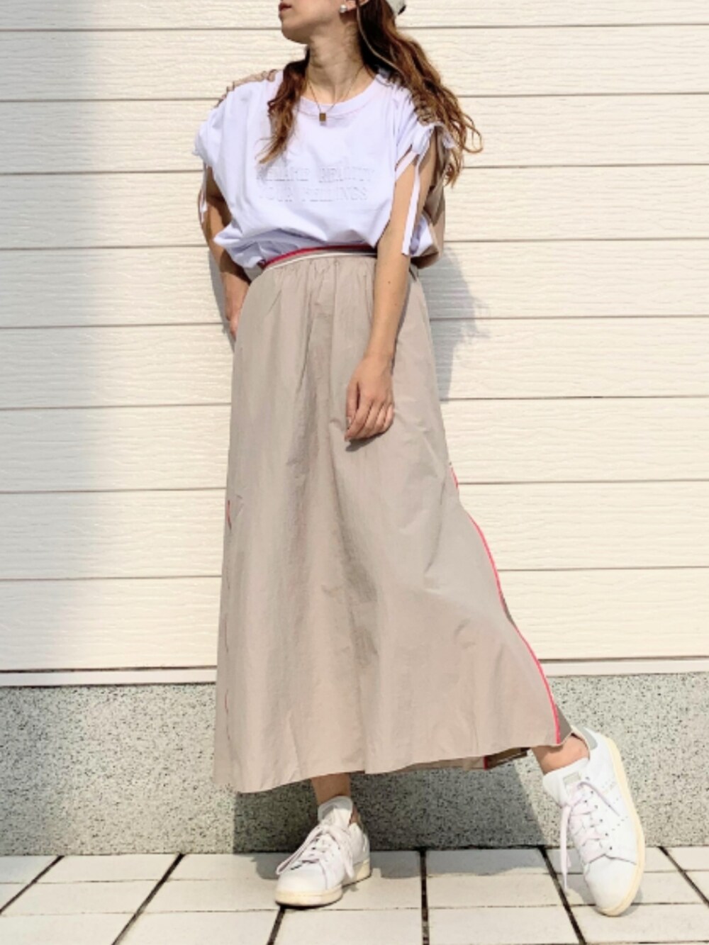 ホワイト系のスニーカー、ホワイト系のTシャツ/カットソー、ベージュ系のスカートを着用したレディースの夏コーディネートの2枚目の写真