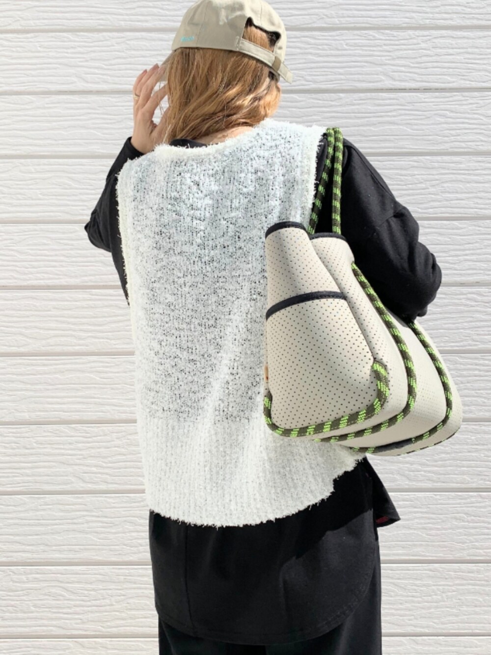 グレー系のトートバッグ、ブラック系のスラックス、ブラック系のTシャツ/カットソーを着用したレディースの冬コーディネートの5枚目の写真