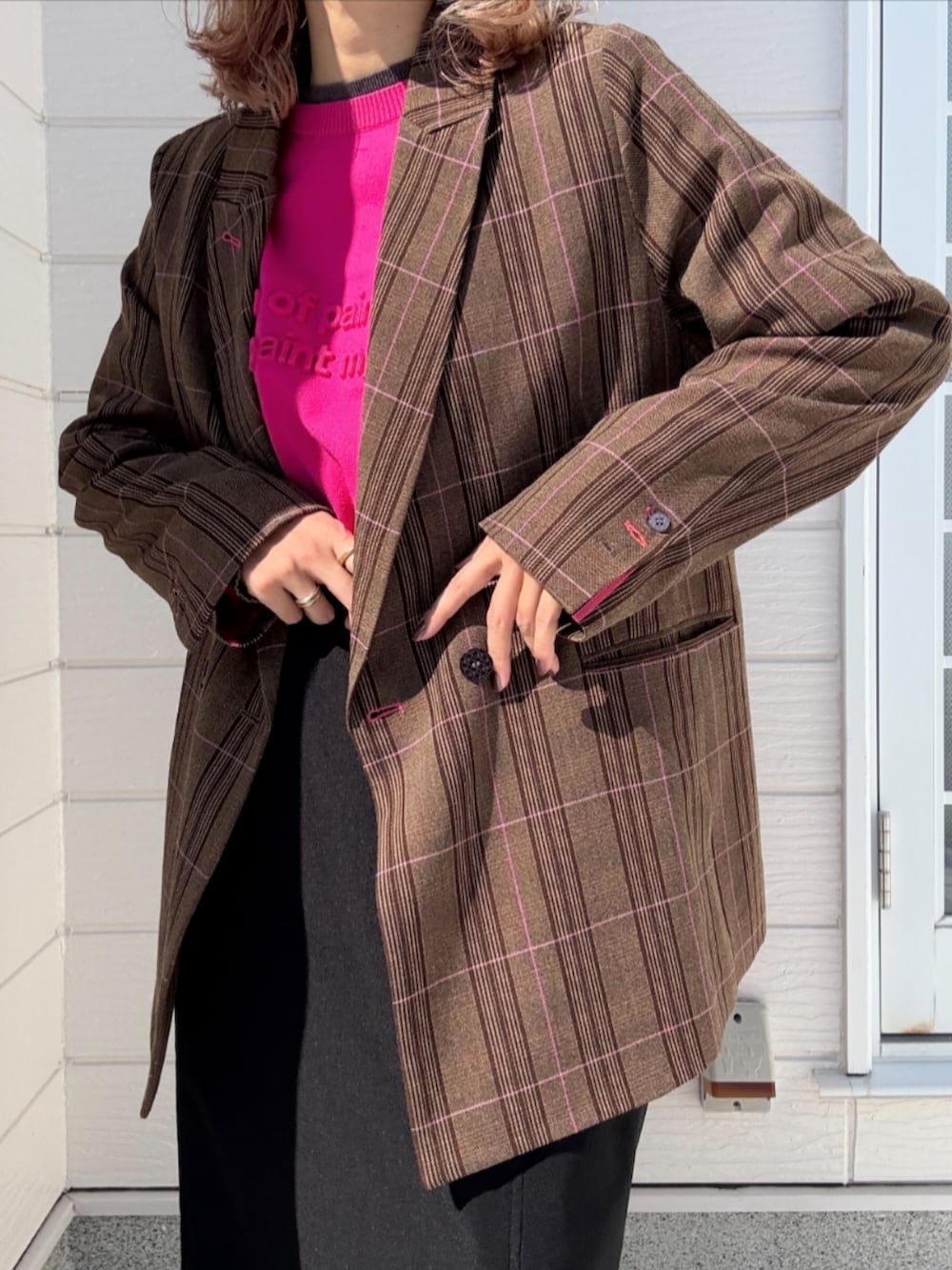 ブラック系のスカート、ブラウン系のテーラードジャケット、ピンク系のニット/セーターを着用したレディースの秋コーディネートの4枚目の写真