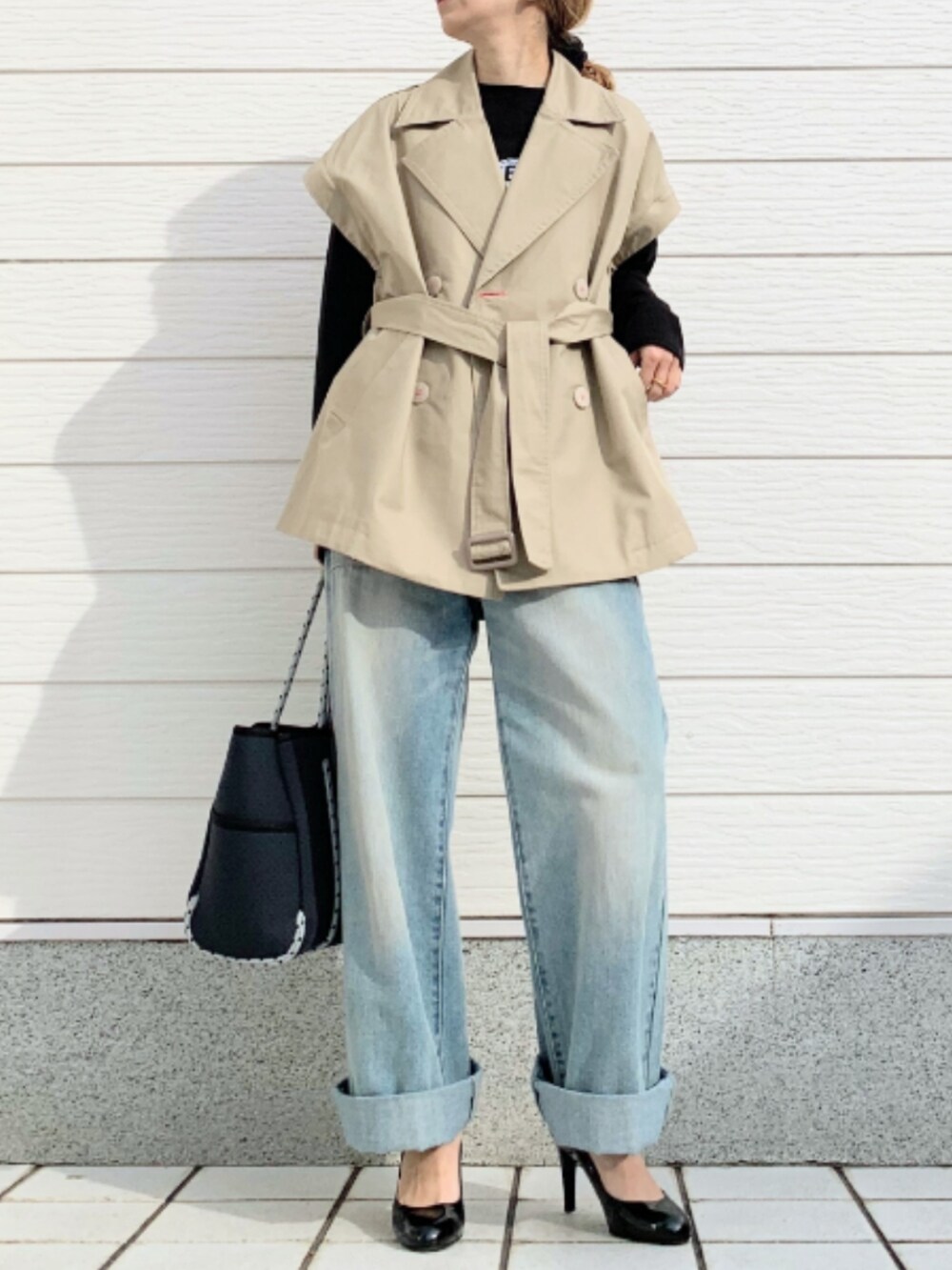 ブルー系のデニムパンツ、ブルー系のトートバッグ、ブラック系のTシャツ/カットソーを着用したレディースの冬コーディネートの2枚目の写真