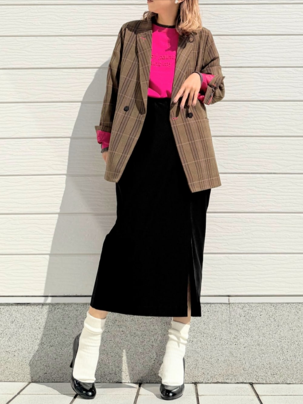ブラック系のスカート、ブラウン系のテーラードジャケット、ピンク系のニット/セーターを着用したレディースの秋コーディネートの2枚目の写真