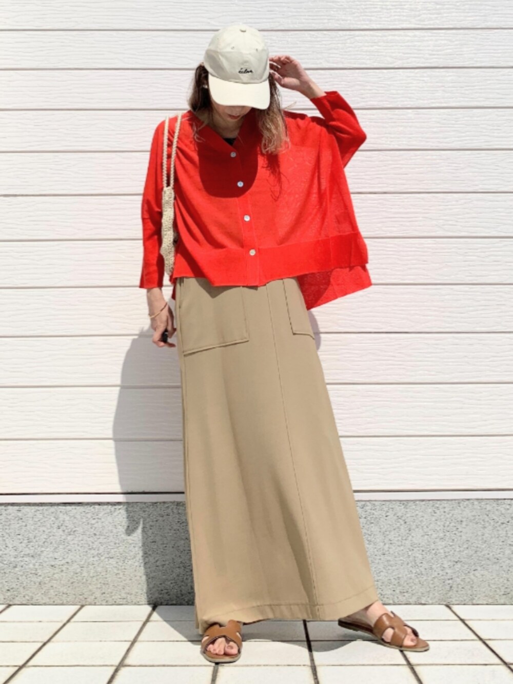 イエロー系のサンダル、オレンジ系のカーディガン/ボレロ、ホワイト系のトートバッグを着用したレディースの春コーディネートの2枚目の写真